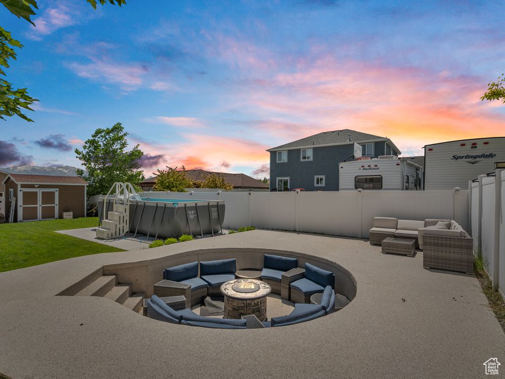 Patio terrace at dusk with an outdoor living space with a fire pit, a patio, and a fenced backyard