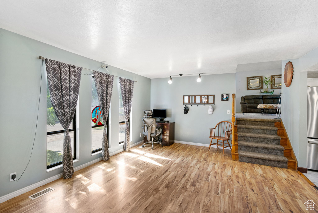 Workout area with wood finished floors, baseboards, and rail lighting