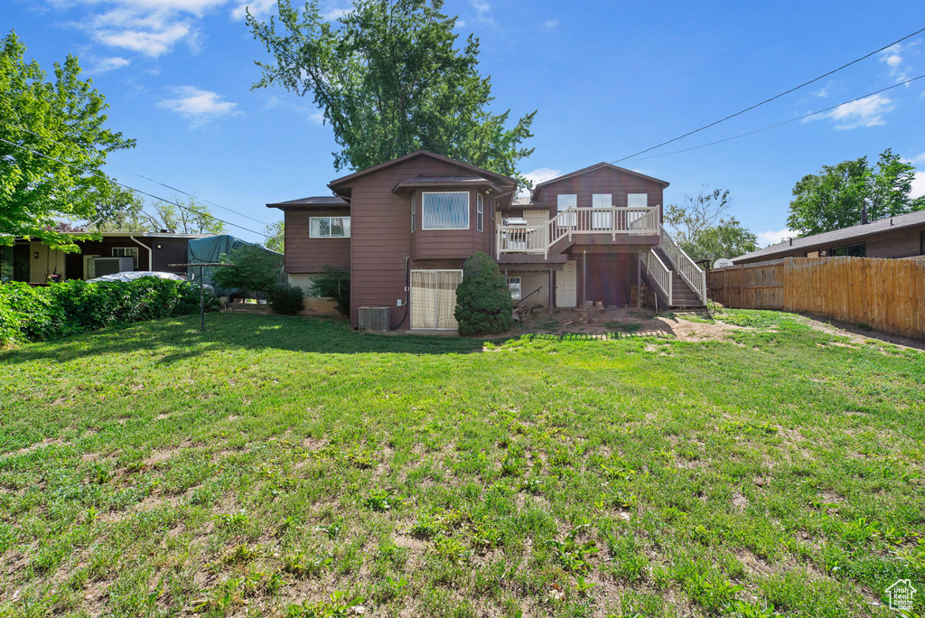 Rear view of property featuring stairway, central AC unit, and a wooden deck