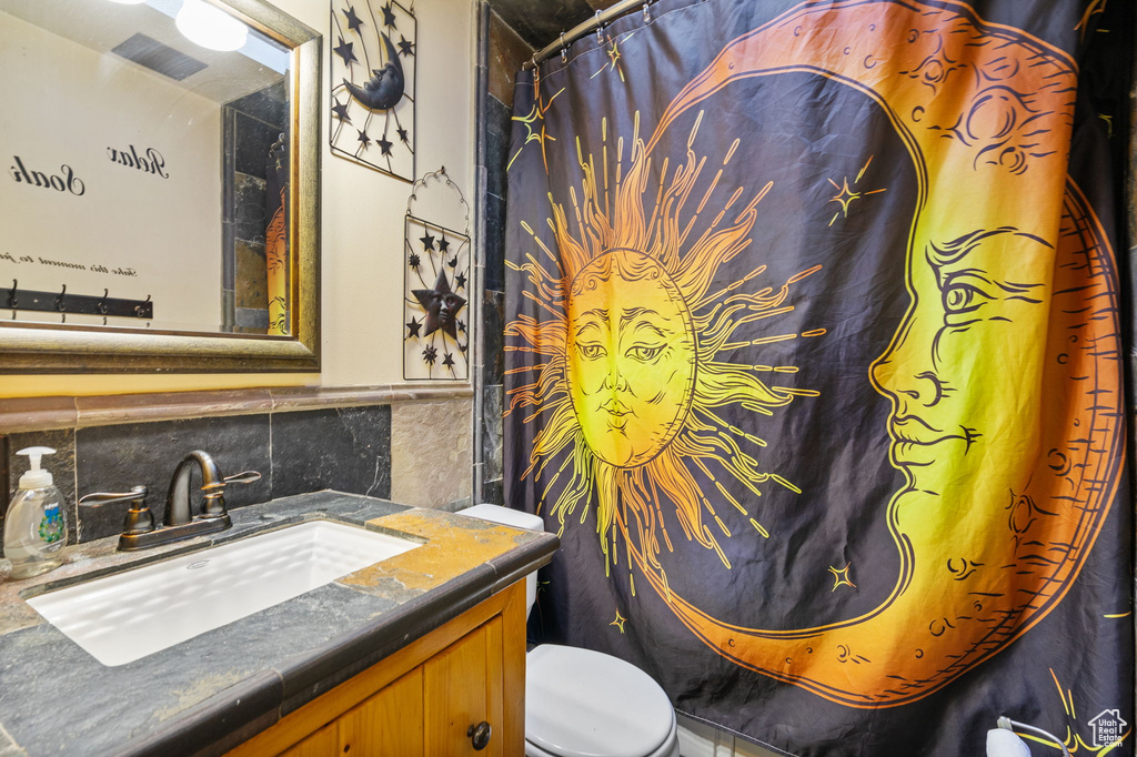 Full bathroom featuring toilet, tile walls, vanity, and a shower with curtain