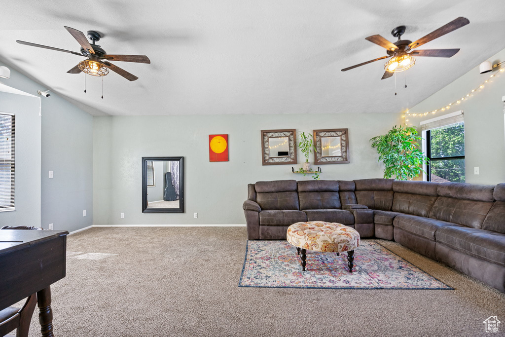 Carpeted living room with ceiling fan, lofted ceiling, and baseboards