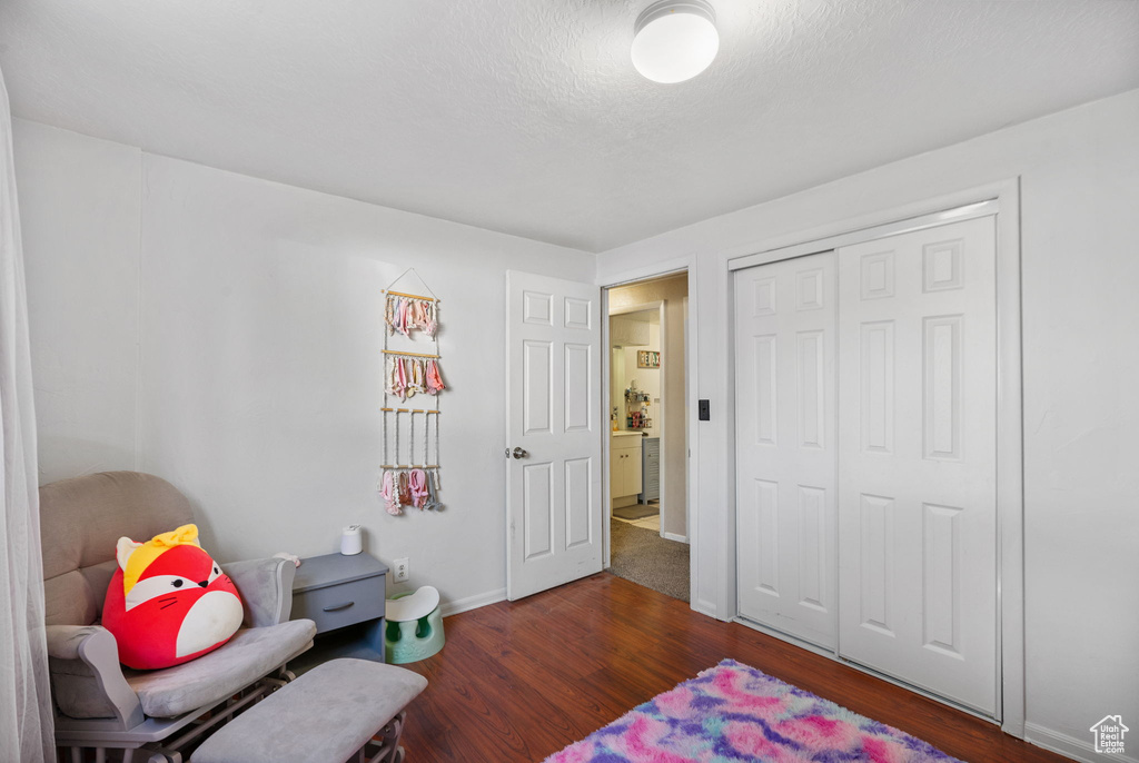 Bedroom with wood finished floors, baseboards, and a closet
