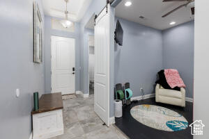 Entryway with a barn door, a ceiling fan, baseboards, and recessed lighting