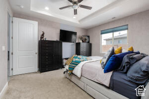 Bedroom featuring a tray ceiling, carpet, recessed lighting, baseboards, and ceiling fan