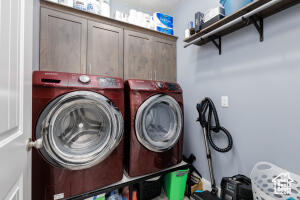 Laundry area featuring washing machine and clothes dryer and cabinet space