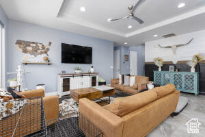 Living area featuring recessed lighting, a ceiling fan, and a raised ceiling
