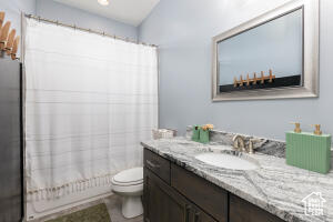 Full bath with vanity, toilet, and shower / tub combo with curtain