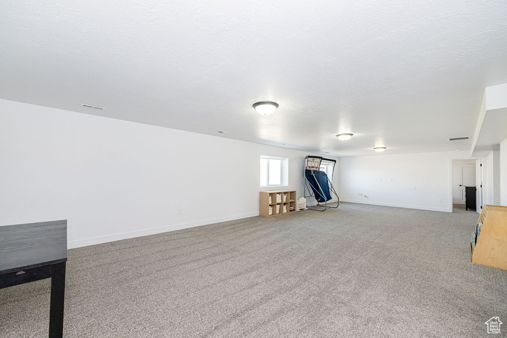Basement featuring light carpet and baseboards