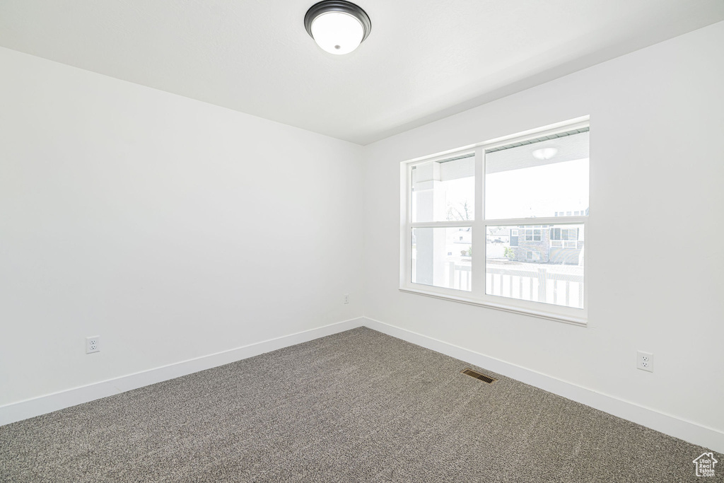 Carpeted spare room with baseboards