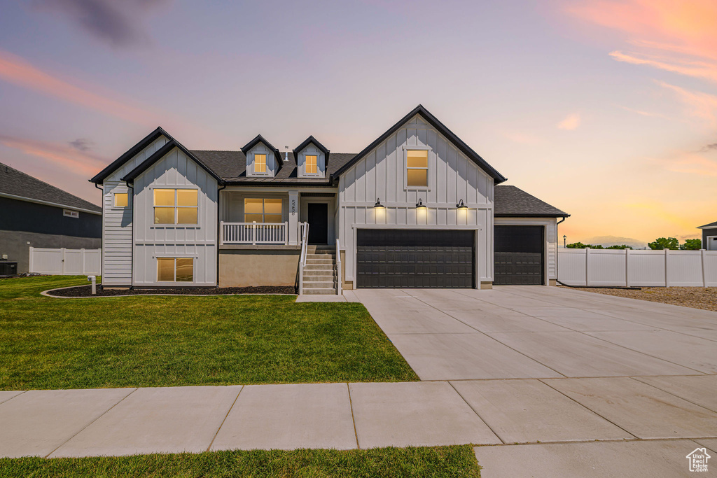 Modern inspired farmhouse featuring board and batten siding, concrete driveway, covered porch, and a garage