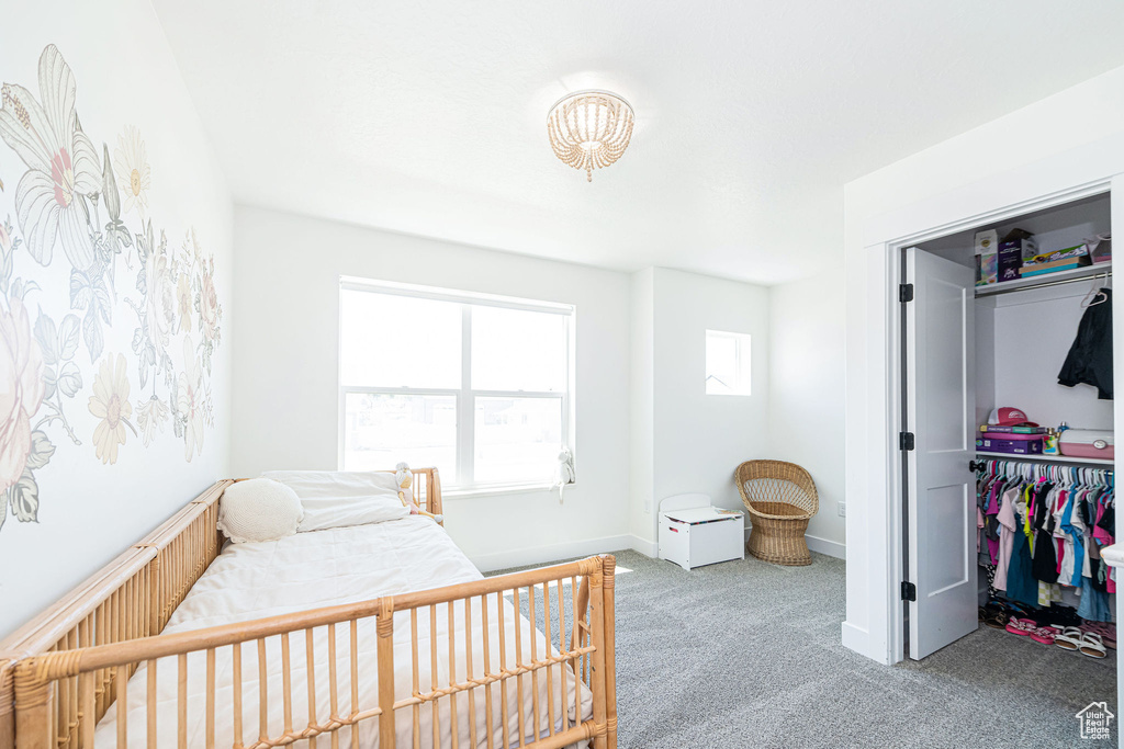Carpeted bedroom with baseboards and a closet