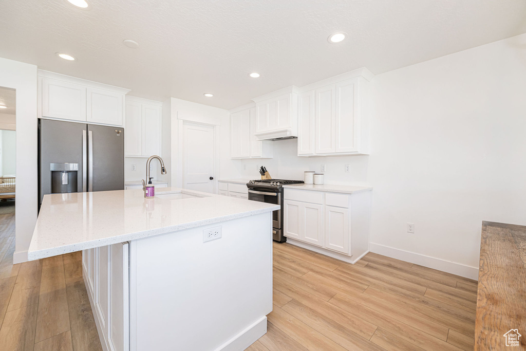 Kitchen featuring a sink, appliances with stainless steel finishes, light wood-style floors, white cabinetry, and recessed lighting