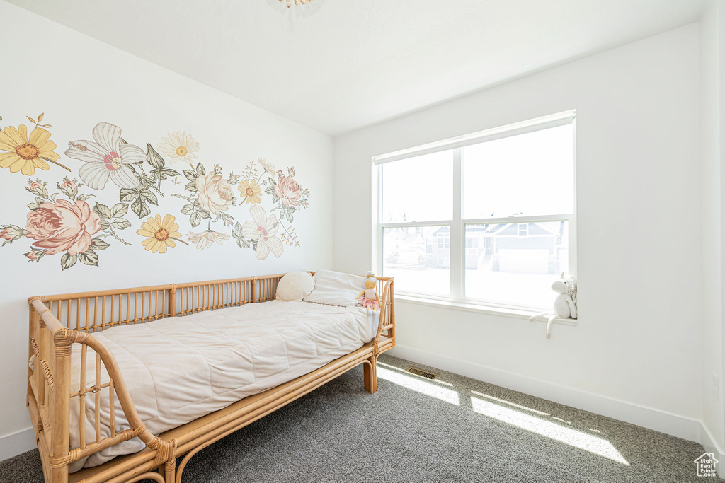 Bedroom featuring carpet and baseboards