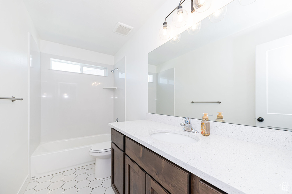 Bathroom featuring vanity,  shower combination, and toilet