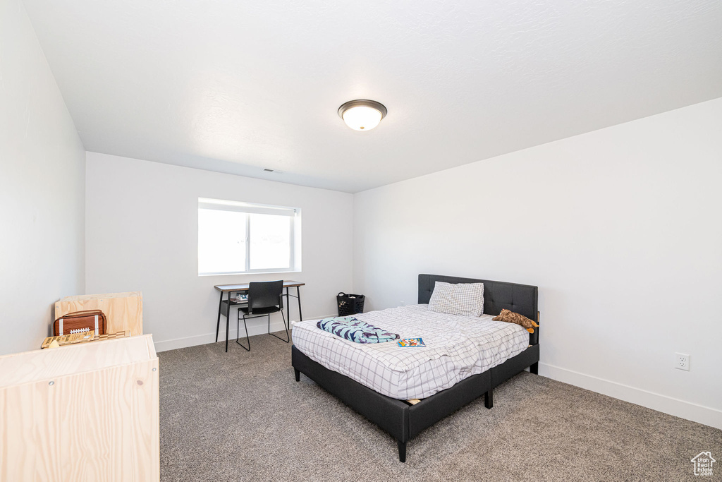 Bedroom featuring carpet flooring, baseboards, and a desk