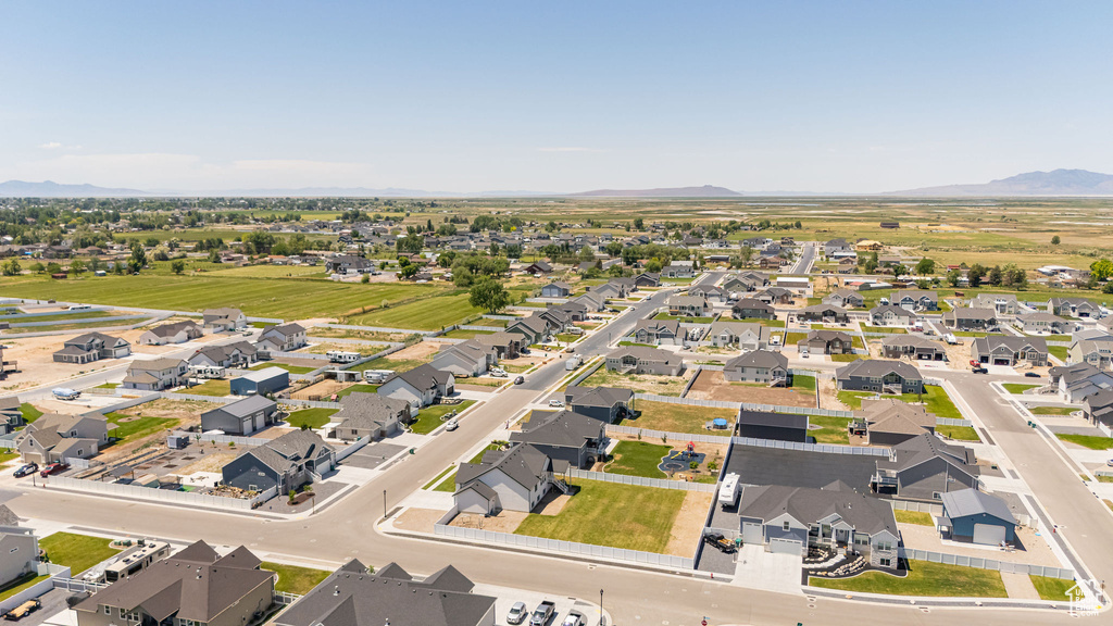 Aerial view of property and surrounding area featuring a mountainous background and nearby suburban area