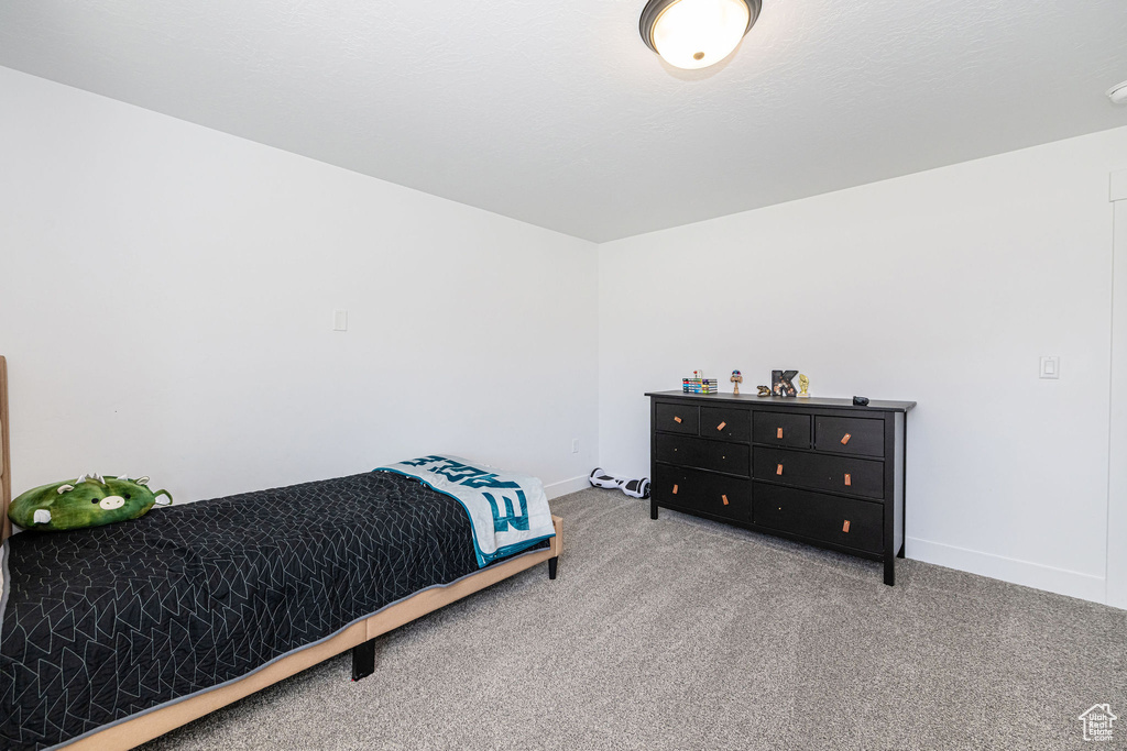 Bedroom featuring carpet and baseboards