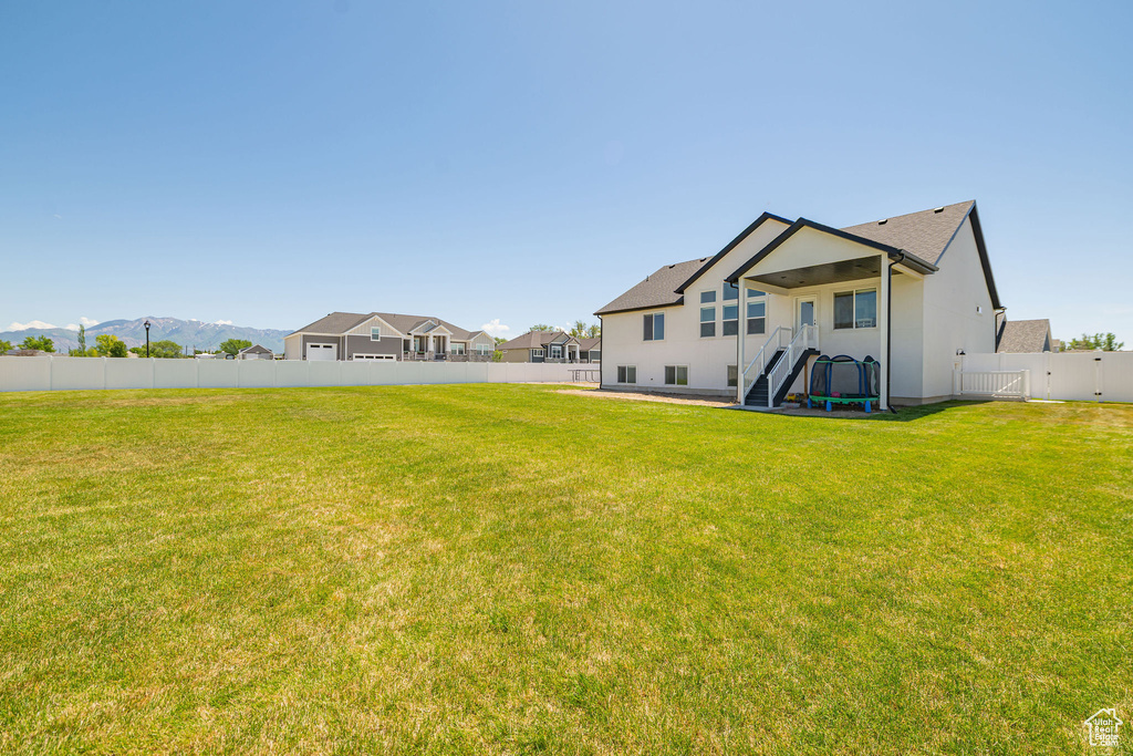 Back of house with a gate and stucco siding