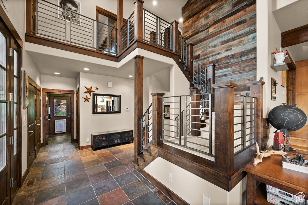 Foyer with a high ceiling, stairway, stone tile floors, baseboards, and recessed lighting