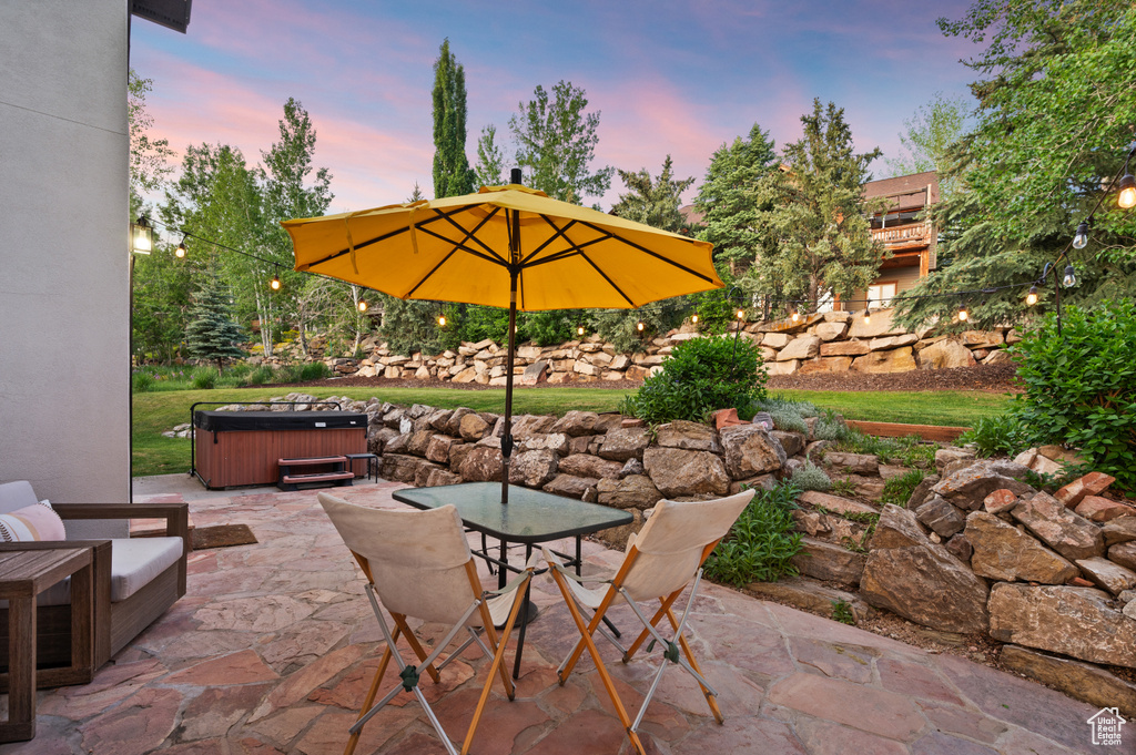 View of patio / terrace with a hot tub and outdoor dining space