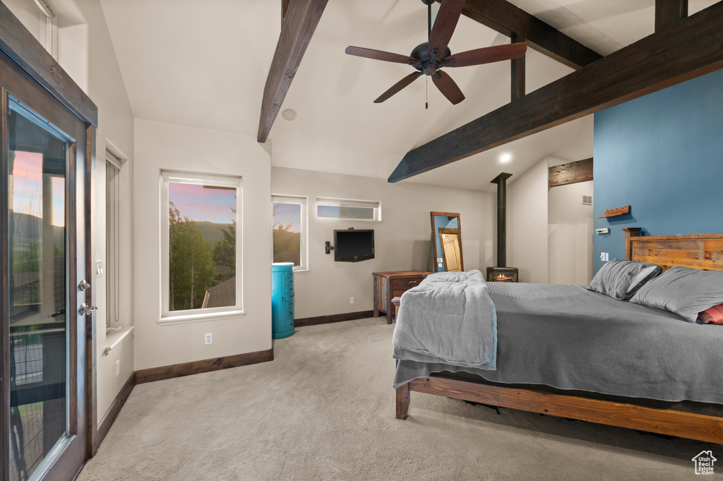 Carpeted bedroom featuring baseboards, a wood stove, access to exterior, and ceiling fan