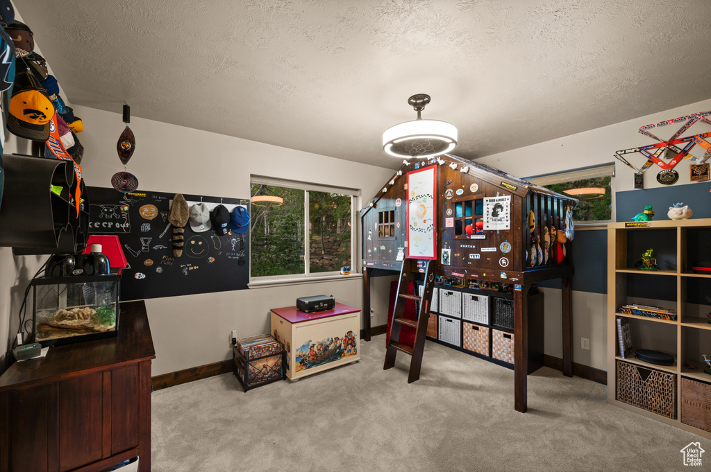 Bedroom featuring a textured ceiling, carpet, and baseboards