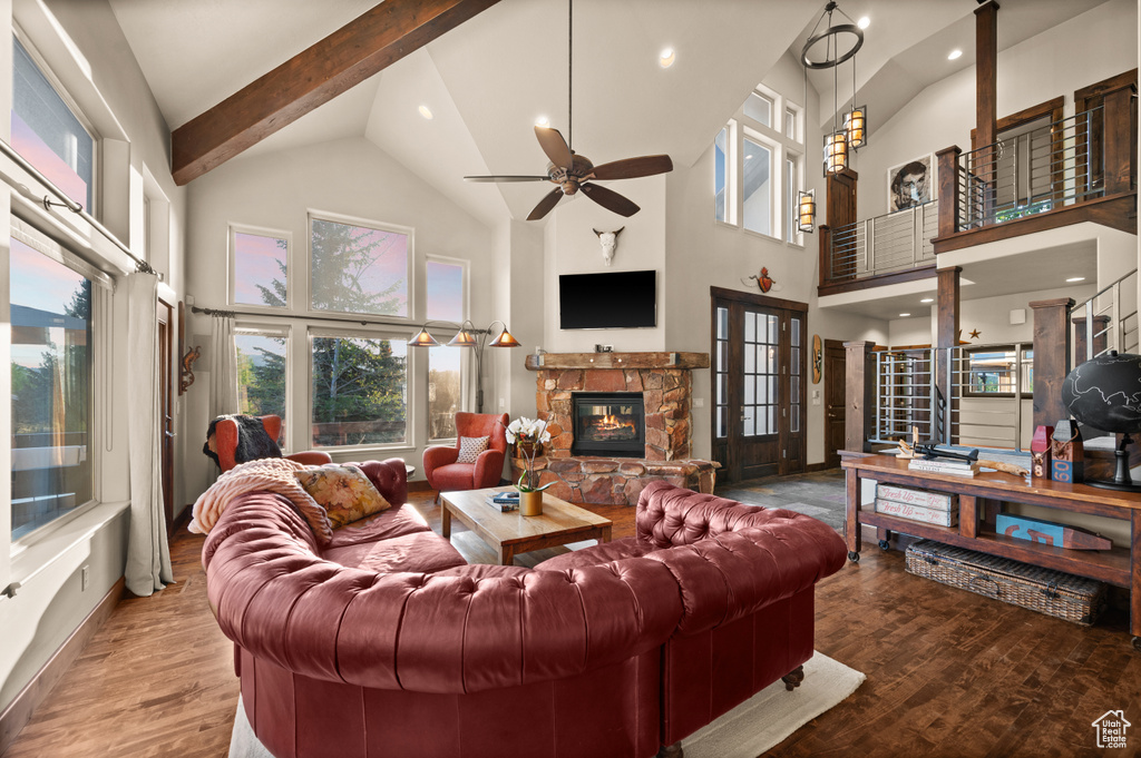 Living room with high vaulted ceiling, a stone fireplace, ceiling fan, wood finished floors, and recessed lighting