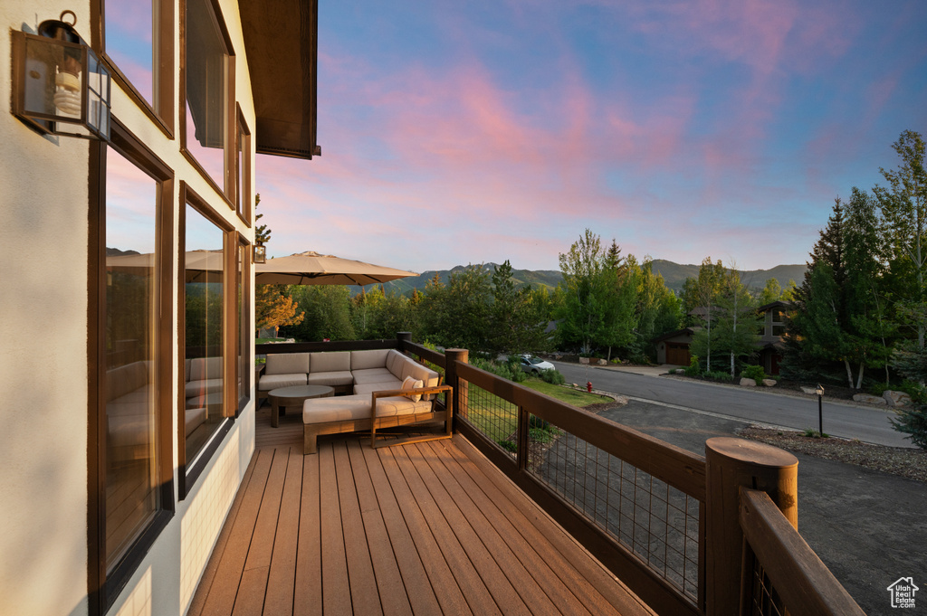Deck at dusk featuring outdoor lounge area and a mountain view