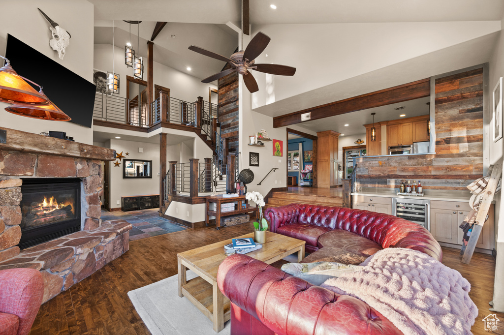 Living area featuring high vaulted ceiling, a fireplace, wine cooler, ceiling fan, and wood finished floors