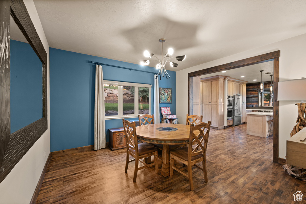 Dining room featuring a chandelier, wood finished floors, and baseboards
