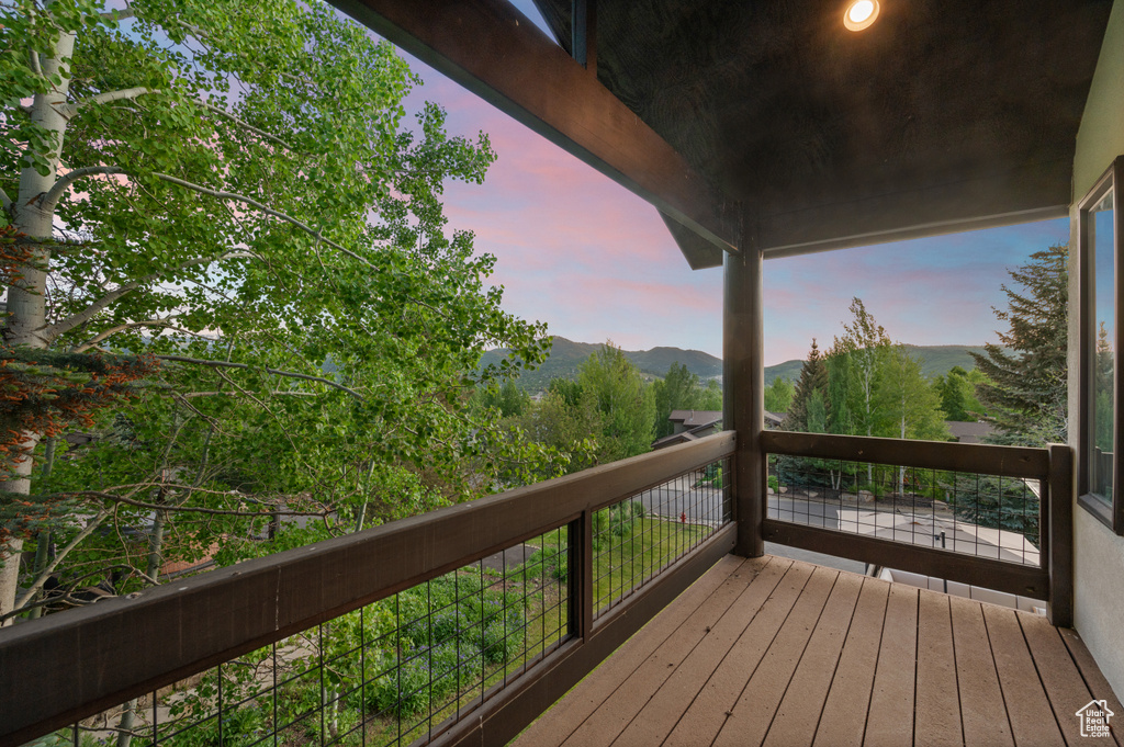 Deck at dusk featuring a mountain view