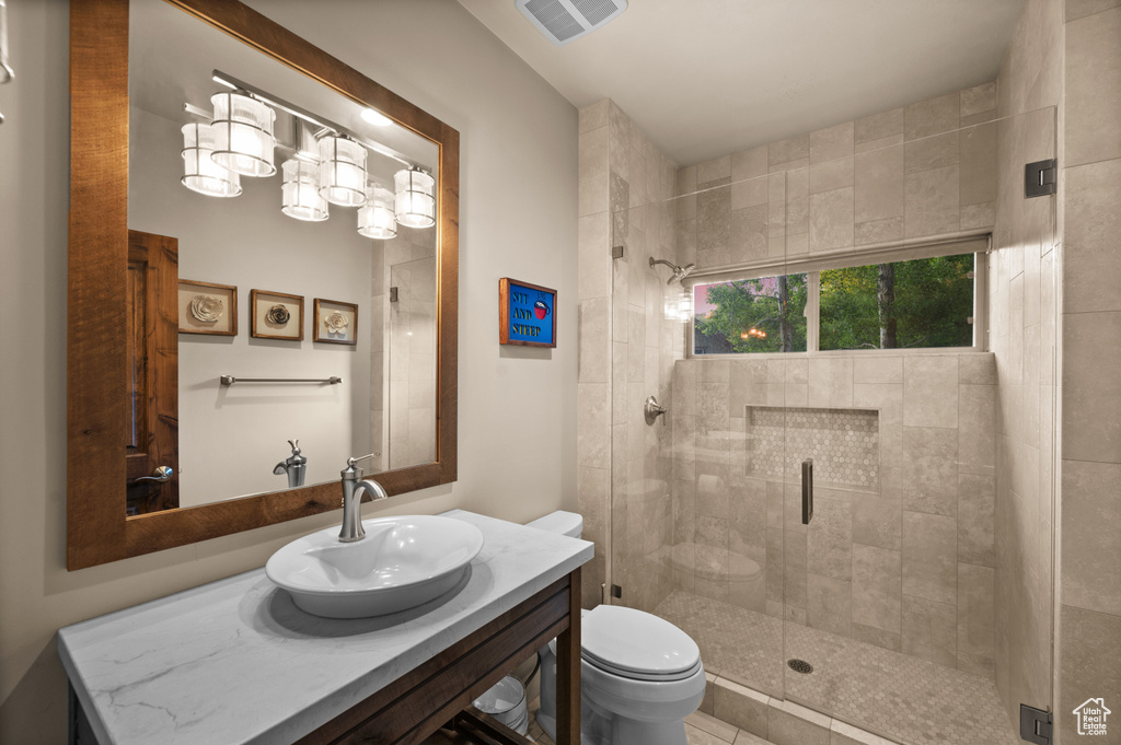 Full bath featuring toilet, a stall shower, and vanity