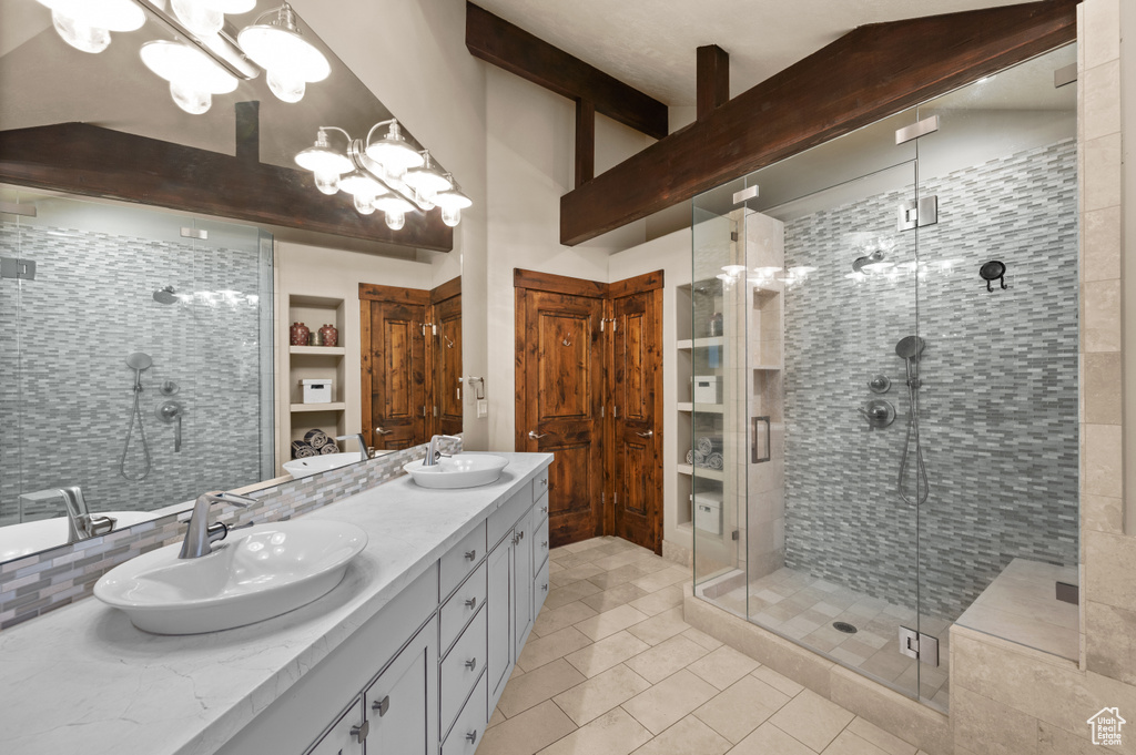 Full bath with double vanity, a shower stall, a chandelier, tile patterned floors, and tasteful backsplash