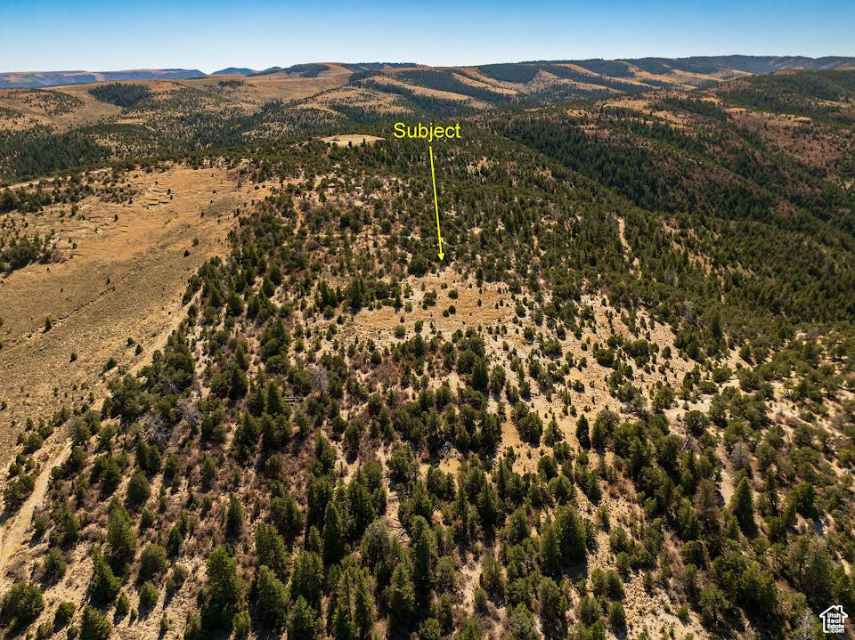 View of property location with a mountainous background and property boundaries highlighted