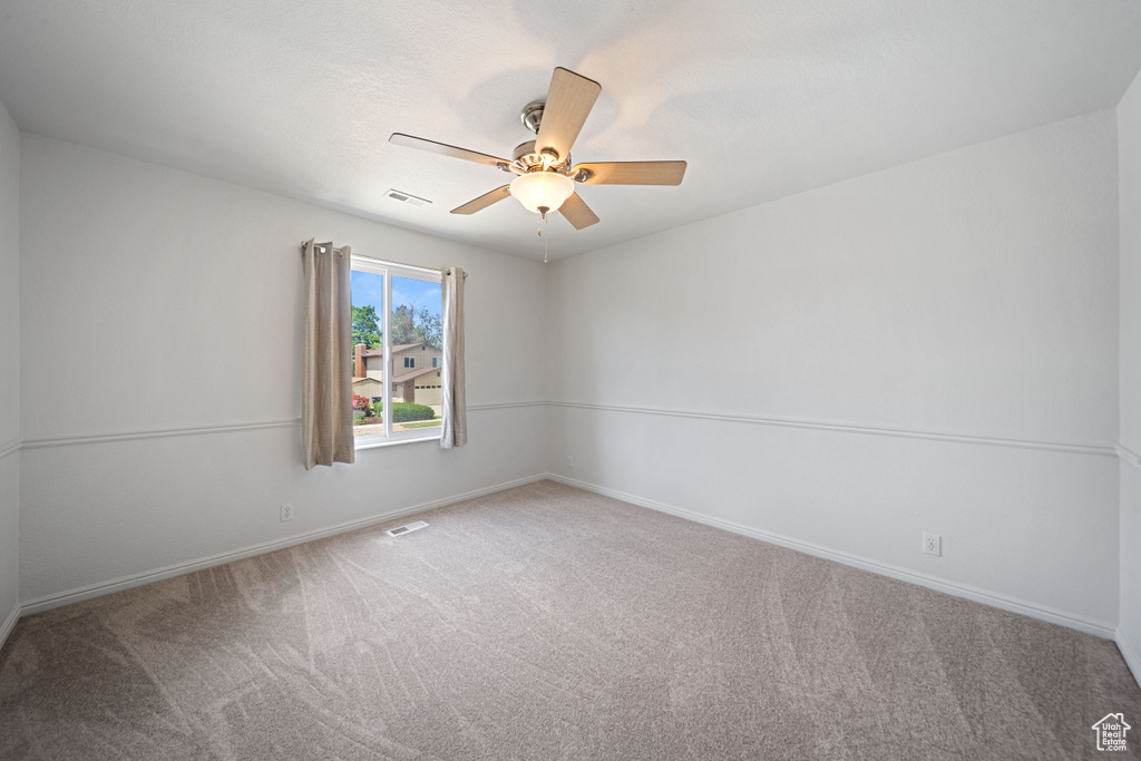 Unfurnished room with carpet floors, ceiling fan, and baseboards