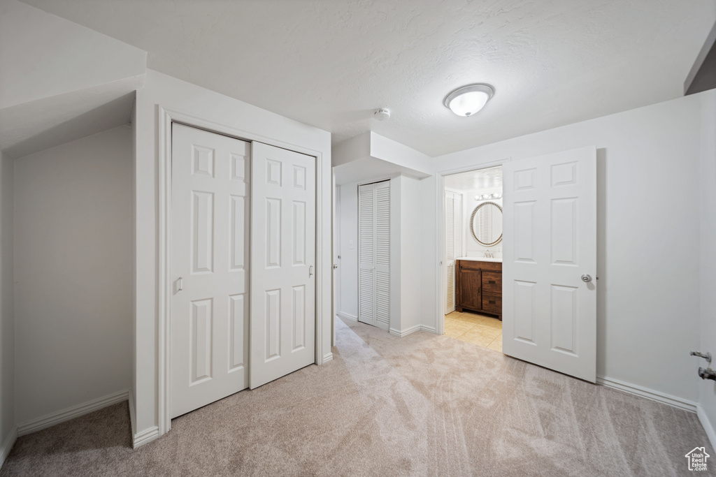 Unfurnished bedroom with carpet floors, baseboards, and ensuite bathroom