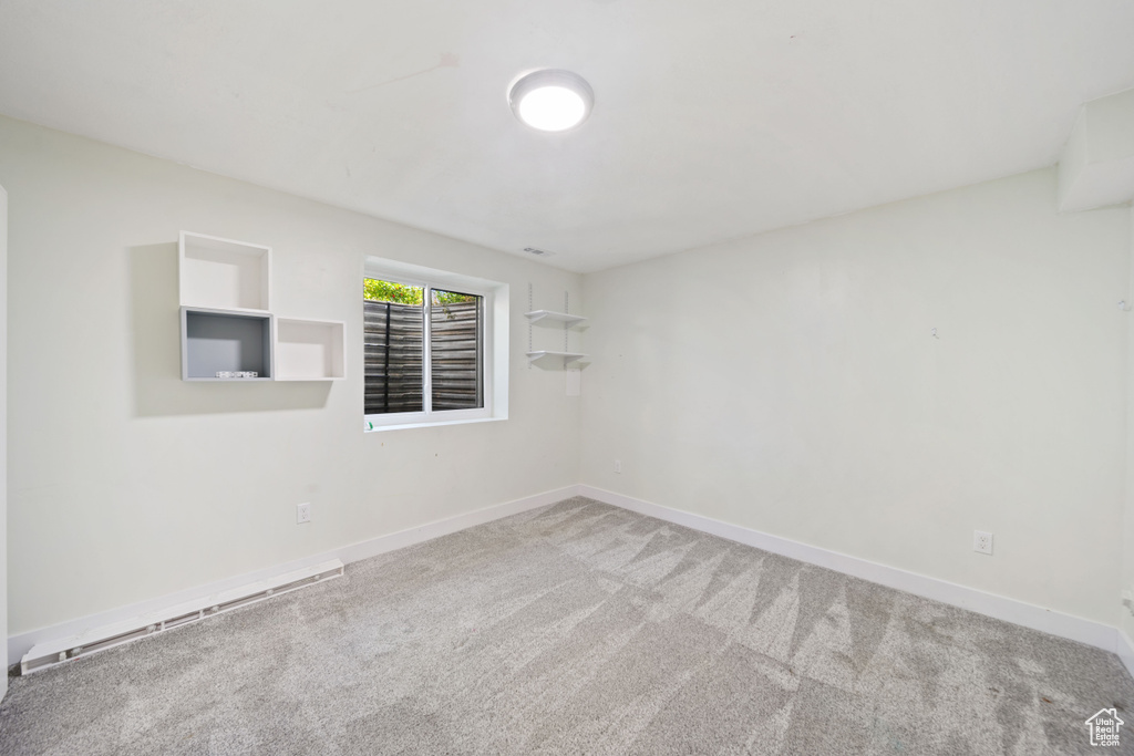 Empty room with carpet floors, baseboards, and a baseboard radiator