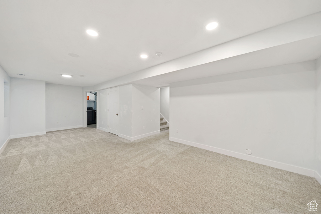 Finished basement featuring stairway, baseboards, recessed lighting, and light colored carpet
