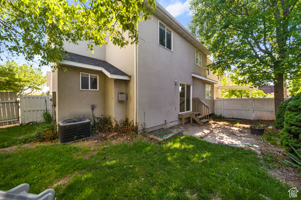 Back of property featuring central AC unit, a patio, stucco siding, and entry steps