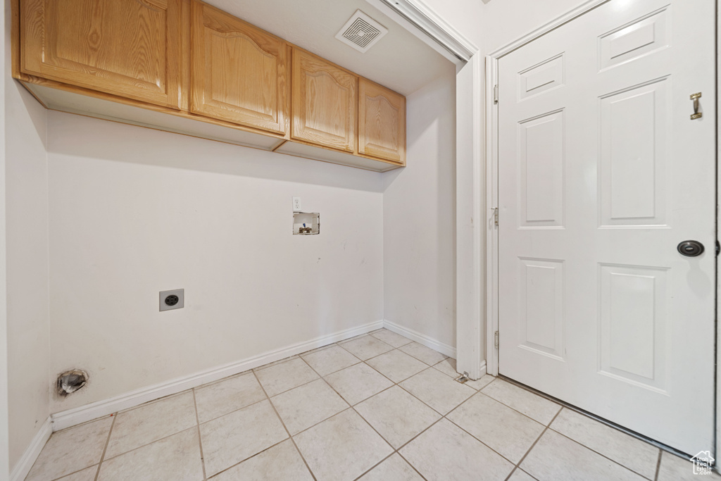 Laundry area featuring baseboards, hookup for an electric dryer, light tile patterned flooring, washer hookup, and cabinet space