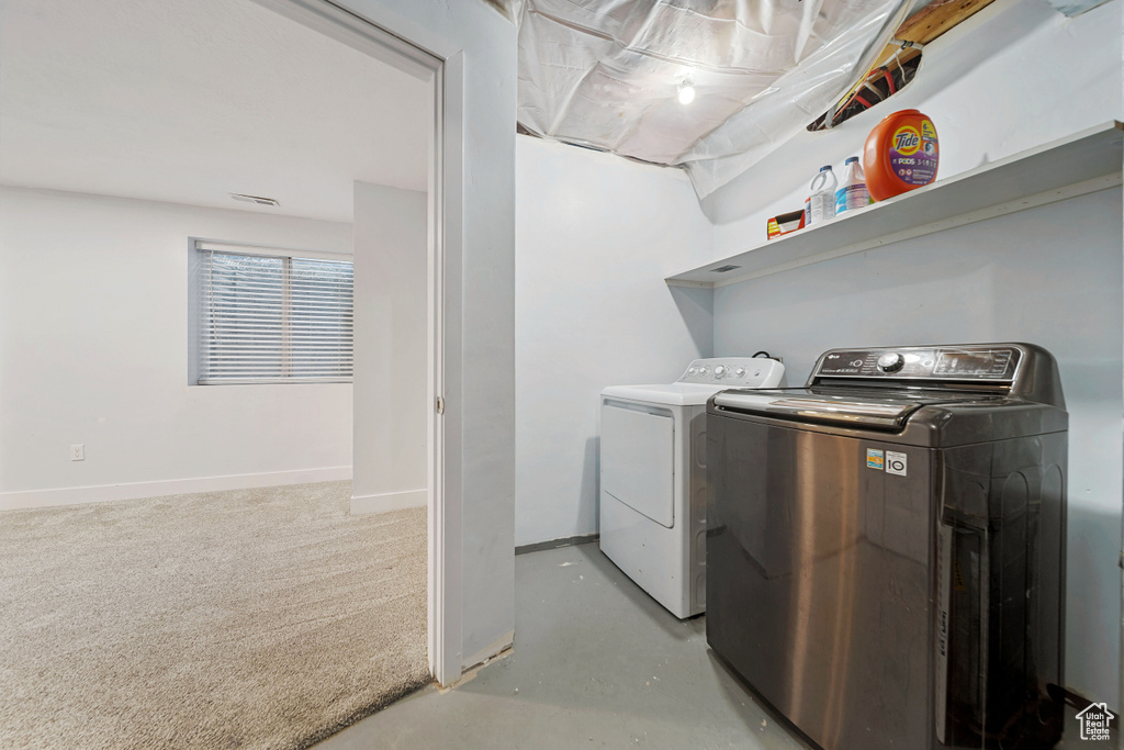 Washroom featuring washing machine and dryer and baseboards