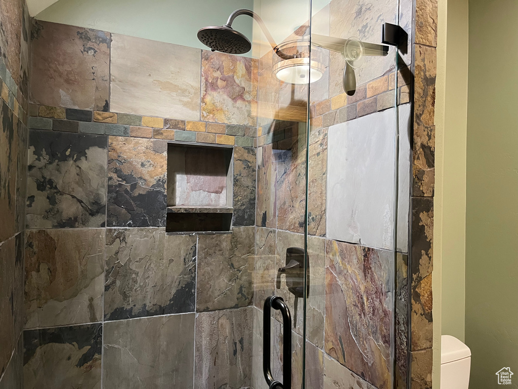 Bathroom view of a shower stall and toilet