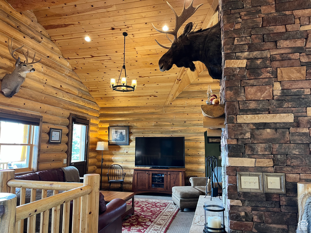 Living room with log walls, wood ceiling, a chandelier, and high vaulted ceiling
