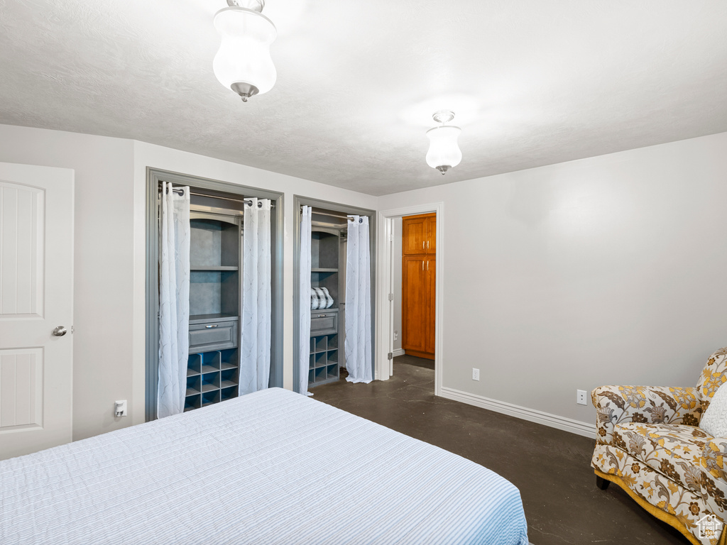 Bedroom featuring concrete floors and baseboards