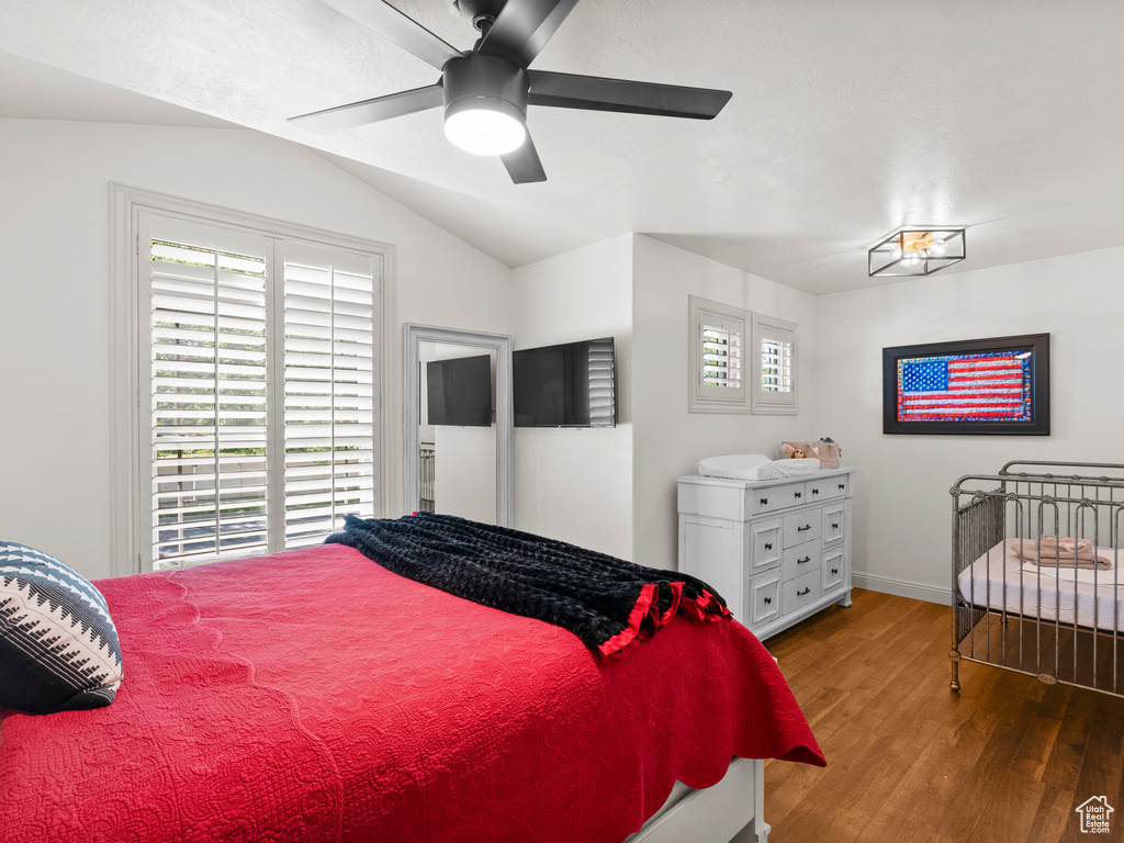 Bedroom with wood finished floors, vaulted ceiling, baseboards, and ceiling fan
