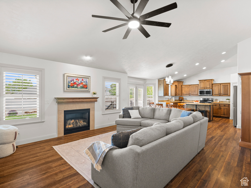 Living area featuring vaulted ceiling, recessed lighting, a ceiling fan, dark wood-type flooring, and a tile fireplace