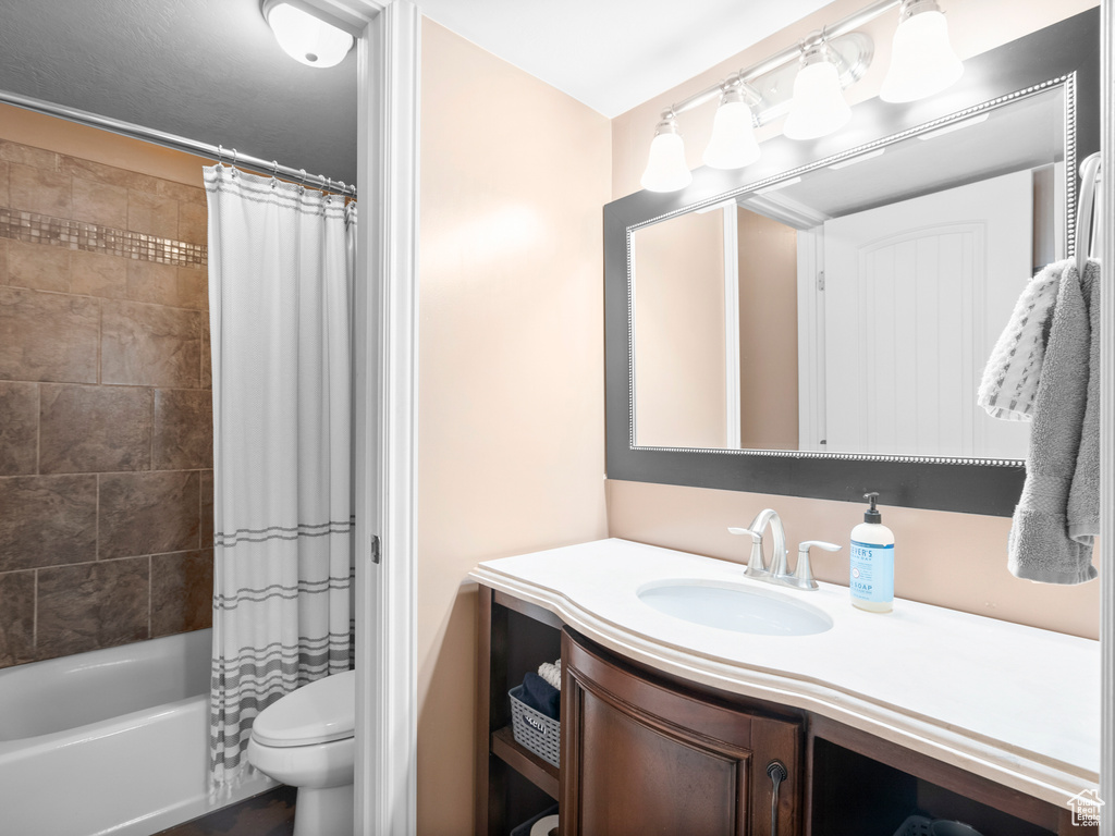 Bathroom with vanity, toilet, and shower / tub combo