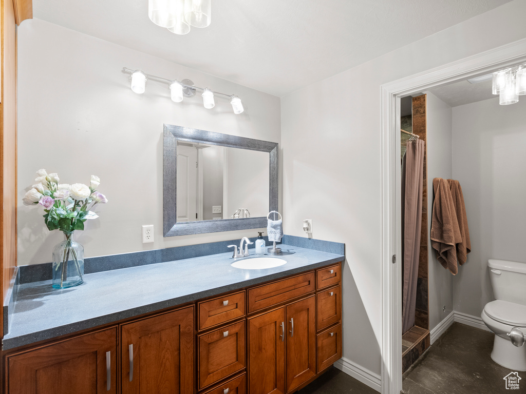 Bathroom with toilet, vanity, a shower with curtain, and baseboards