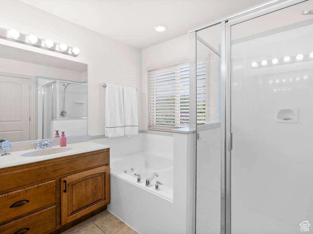 Bathroom with a stall shower, vanity, a whirlpool tub, and tile patterned floors