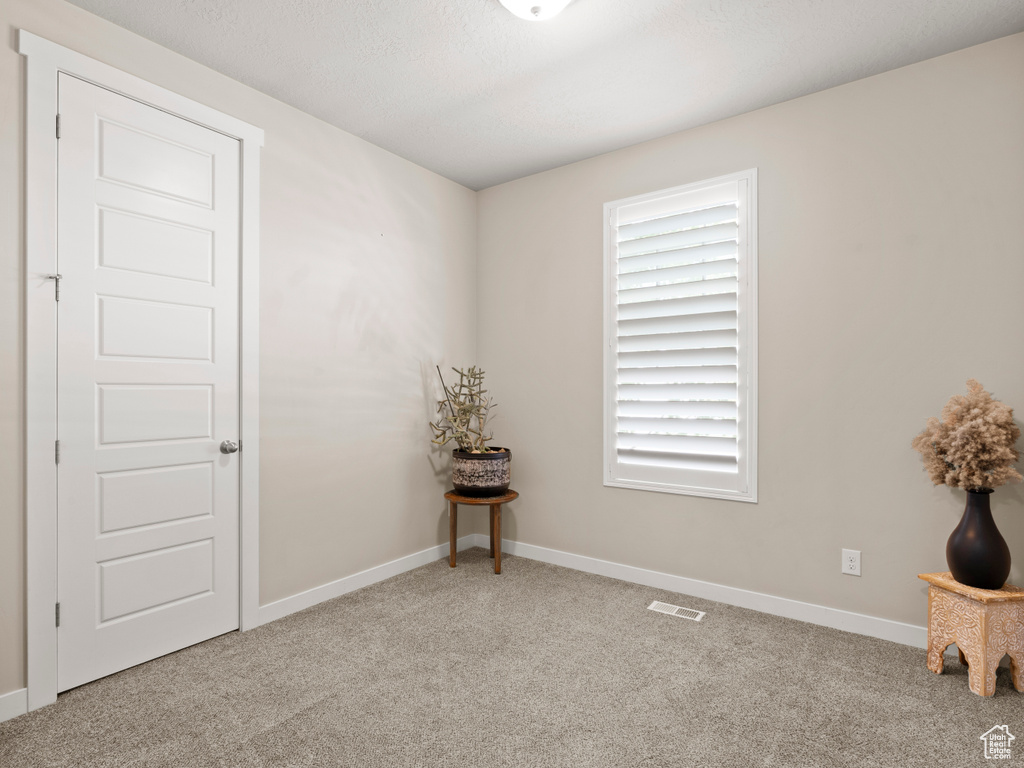 Carpeted empty room with baseboards